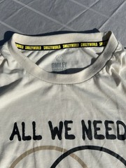 Smiley World ” All We Need Is Positivity ” Off White Mens T-Shirt L/G New w/oTag