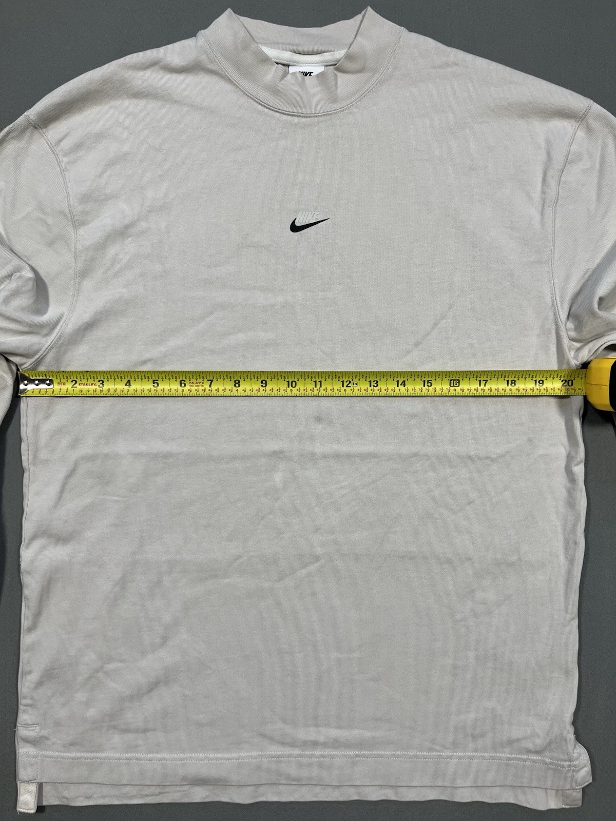Nike long sleeve mock neck top in Light Bone featuring a small swoosh logo gallery