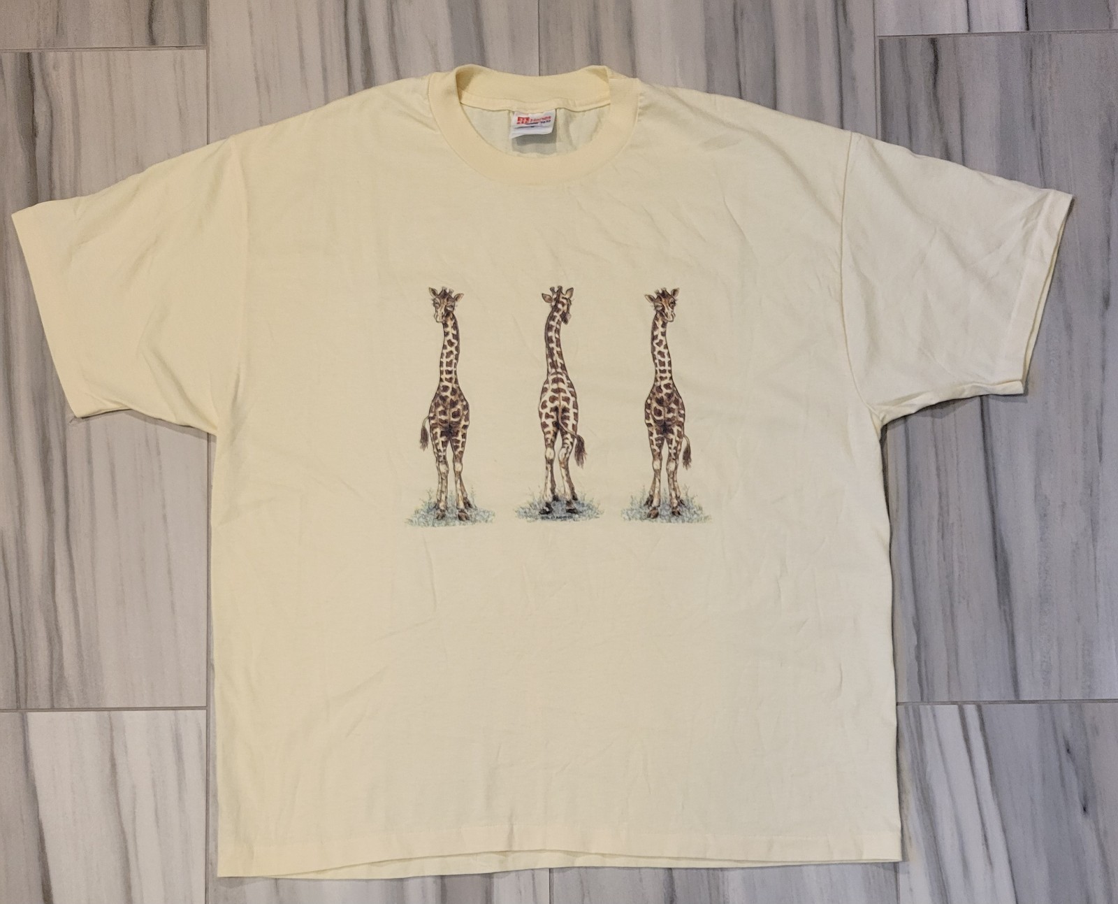VTG XL Pale Yellow Hanes T-shirt features a Graphic of Three Giraffes
